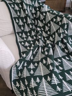 a green and white blanket sitting on top of a couch