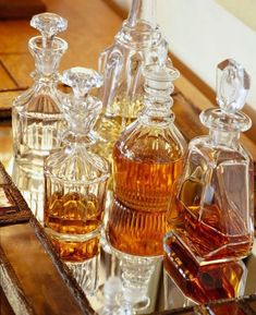 an assortment of glass bottles sitting on top of a wooden table