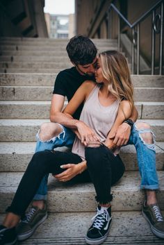 a man and woman sitting on steps kissing