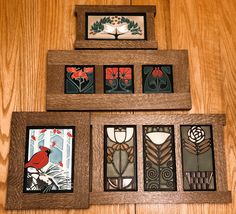 four stained glass panels are displayed on a wooden surface, including one with a cardinal and the other with red flowers