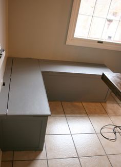 an empty room with a sink and countertop in it, next to a window