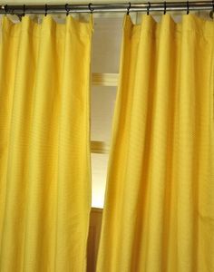 a yellow curtain hanging on the side of a window