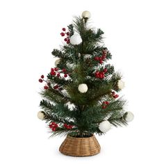 a small christmas tree in a wicker basket with red berries and white balls on it