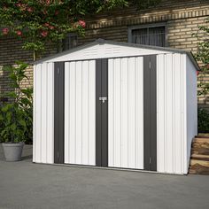 a white and black shed sitting in front of a brick building