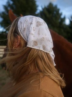 Our bandanas are not only versatile, they are trendy + unique too. Wear them around your head many different ways, tie around your neck, or accent your bags! It measures in a square shape approximately 20x20 inches long. Style in a ponytail, wear around your neck, on a bag, or on top of your head. This is a neutral print print is bringing the best of coastal cowgirl vibes. This bandana comes in a KAXI original print made up of cowboy hats, cactuses, saloon and horses. This is our most ICONIC KAX Coastal Cowgirl Hair, Lesbian Outfits Feminine, Lesbian Cowboy, Cowgirl Winter Outfits, Cowgirl Winter, Cowgirl Bandana, Summer Cowgirl, Cowgirl Vibes, Lesbian Outfits