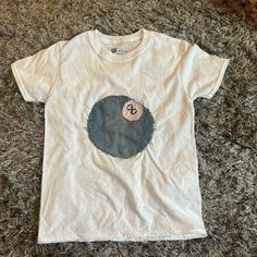 a white t - shirt with a blue circle on it