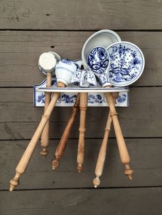 an assortment of blue and white dishes on wooden stand