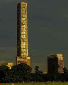 the tall building has many windows on it's sides and is lit up at night