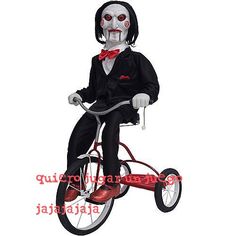 a creepy man riding a tricycle with red wheels and a bowtie on it's head