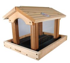 a wooden bird house with a window and roof