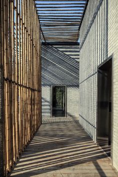 an empty room with wooden slats on the walls and floor, leading to a doorway