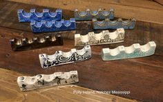 several different types of ceramic objects sitting on a wooden table with wood planks in the background