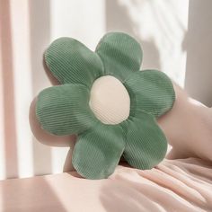 a green flower sitting on top of a bed