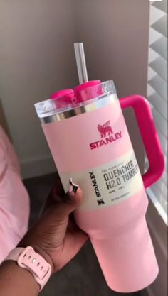 a person holding a pink tumbler cup in their hand