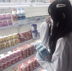 a woman standing in front of a store filled with milk