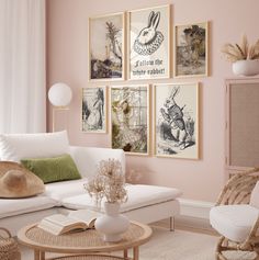 a living room with pink walls and pictures on the wall above the couch, coffee table