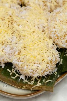 some type of food on a plate with cheese and green leafy leaves in the foreground