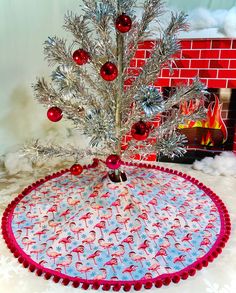 a small christmas tree in a red and blue pot holder