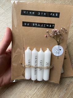 four white candles tied with twine in front of a brown card that says, say it's friday