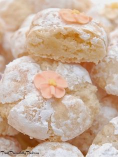 powdered sugar cookies with flowers are piled on top of each other in a pile