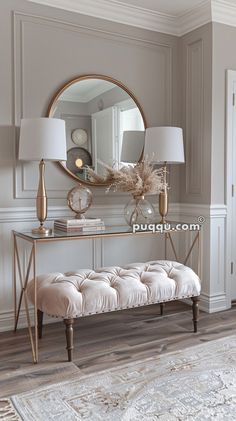 a white bench sitting in front of a mirror and lamp on top of a wooden floor