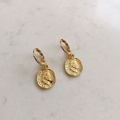 Dainty gold dangle coin earrings. These gold huggie earrings feature a tiny Italian lira coin charm. Delicate and yet eye catching. The ultimate accessory for every outfit, day to night. made of 14k gold plating over brass. Measurements: Diameter- 10mm Coin charm- 12xmm Shipping: Please allow 1-3 business days for your order to be processed and shipped. All orders are shipped in our customize box, gift ready. *Let me know if you have any questions and I will promptly respond Coin Shaped Earrings As A Gift, Nickel Free Coin Shaped Earrings For Gift, Nickel-free Coin Shaped Earrings For Gifts, Everyday Gold Plated Coin Jewelry, Gift Coin Pendant Drop Earrings, Coin Pendant Earrings For Gifts, Coin Pendant Earrings As Gift, Round Coin Pendant Earrings For Gifts, Round Coin Pendant Earrings As Gift