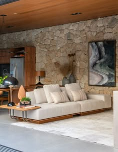 a living room filled with furniture next to a stone wall