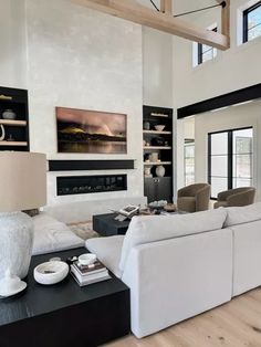 a living room filled with furniture and a fire place in the middle of a room