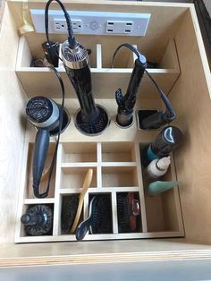 an open drawer with hairdryers and other items