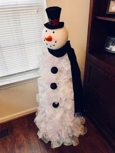 a snowman made out of ruffles in front of a window