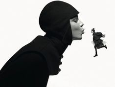 a woman in a black hoodie is looking at a flying bird