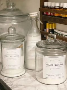 three jars with labels on them sitting on a counter next to other bottles and containers