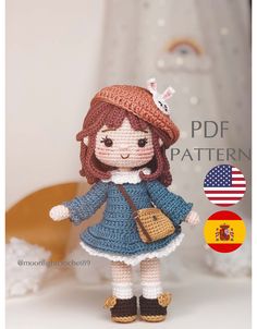 a crocheted doll wearing a blue dress and hat with a cat on her head