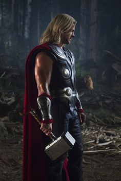 thor is standing in the woods with his hammer