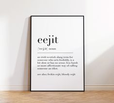 a poster with the words eejit on it in front of a white wall and wooden floor