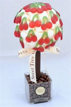 a small potted plant with red and green leaves on it's top, in front of a white background