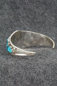 This turquoise and sterling silver bracelet was made by Zuni silversmith Vangie Tsabetsaye. The inside is signed Tsabetsaye and sterling.Size: 5 1/4" (will fit up to a 6 1/2" wrist)Gap: 1 1/4"Width: 1" tapered to 1/8"Free shipping on all orders! We ship with USPS and always include tracking. All orders ship within a day of payment.Returns are accepted up to 30 days after you receive your order. Just send us a message. Our shop offers cash back or store credit. The item must be returned in new co Turquoise Sterling Silver Bracelet, Adjustable Hallmarked Turquoise Jewelry, Adjustable Turquoise Bracelets With Polished Finish, Adjustable Turquoise Bracelet With Polished Finish, Gift Turquoise Sterling Silver Bracelet, Sterling Silver Turquoise Bracelet Gift, Adjustable Sterling Silver Bracelet With Inlay, Artisan Sterling Silver Bracelet With Inlay, Adjustable Turquoise Bracelet With Inlay