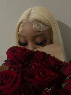 a woman hiding her face behind a bouquet of roses