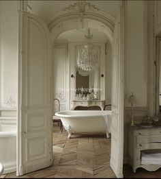 an old fashioned bathroom with a claw foot tub and chandelier in the corner