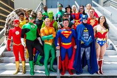 a group of people dressed up as superheros pose for a photo on the steps