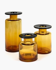 three yellow glass containers with black lids