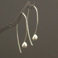 These simple yet elegant silver drops are very comfortable and I so love the feel of them that I haven't worn any other earrings since I created them.  They are made from 18 gauge argentium sterling silver and will hang a little under 2 inches from your piercing.  18 gauge is slightly thicker than the standard ear wire size, however if your piercings are not newly done or tight, these should work.  If you would like them in 20 gauge please indicate in the message to seller.  A wonderful addition to your accessory collection. Thanks for stopping by and please visit again.So I am thinking of posting this in a picture. CANADA - GST/HST included in prices.  Provincial tax, where applicable, is added at checkout. UNITED STATES - taxes included at checkout. Returns are not accepted on worn items Fold Forming, Pendulum Earrings, Bijoux Fil Aluminium, Wooden Necklace, Tiny Stud Earrings, Moonstone Earrings, Drop Dangle Earrings, Unique Handmade Jewelry, Jewelry For Her