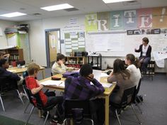 a group of people sitting at desks in a classroom