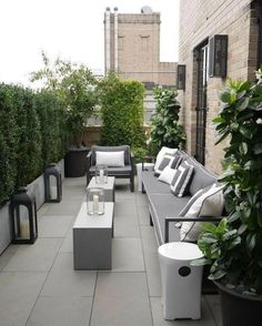 an outdoor patio with couches, tables and potted plants