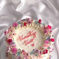 a birthday cake decorated with flowers and the words happy new year on it's frosting