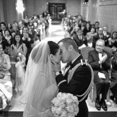 a bride and groom kissing in front of an audience