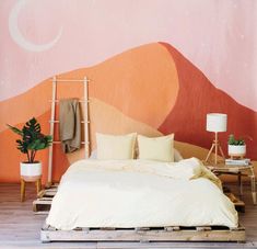 a bed sitting in front of a wall with a painting on it's side