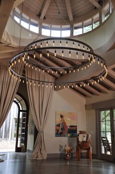 a circular room with curtains and lights hanging from the ceiling