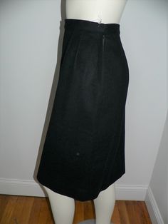 Vintage 1950's - 60's black wool skirt. It is a straight skirt with darts below the waist band on both front and back. There is a side metal zipper and snaps on the side for closure. On one side is 2 long vertical strips of black satin 3 - 4 inches wide. Inside these strips are a series of black satin diamonds starting with one at top then 2 and 3 at the bottom. There is a small back kick pleat. Inside the back set is lined in a black satiny fabric. No labels. Shown on form unpinned and loose at Office Wool Skirt In Black, Classic Wool Pencil Skirt For Formal Occasions, Classic Wool Pencil Skirt For Formal Wear, Formal Wool Pencil Skirt Knee-length, Black Wool Pencil Skirt, Vintage Formal Full Skirt Bottoms, Formal Fitted Retro Skirt, Fitted Black Skirt With Box Pleat, Retro Fitted Skirt For Formal Occasions