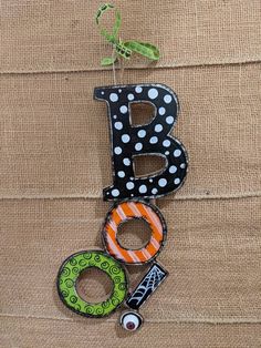 the letter b is made out of wood and decorated with polka dots, stripes, and letters